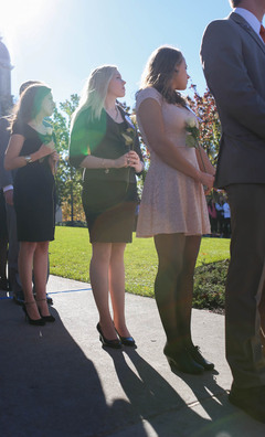 Remembrance Scholar Rebecca Moore, an aerospace engineering major, holds a rose as others speak during the ceremony outside of the Hall of Languages.