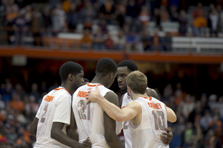 Five Syracuse players huddle on the court. The Orange overcame 17 turnovers to pull out a two-point win.
