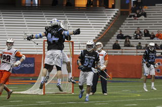 JHU's John Crawley celebrates with a teammate. The Blue Jays went on a 3-0 run to open the game against Syracuse.