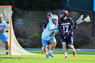 Junior attack Dylan Donahue surveys his options while being pressed by Evan Connell.