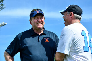 Syracuse head coach John Desko chats with  Tar Heels head coach Joe Breschi before the game.